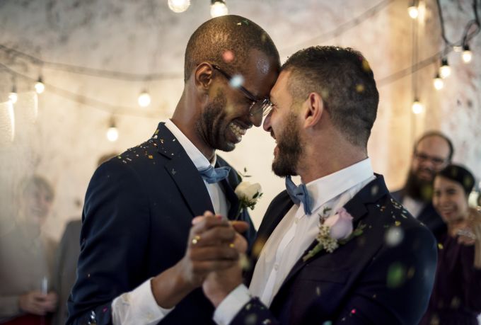 Two grooms dancing together at wedding reception