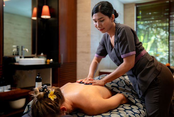Seorang wanita sedang menikmati pijat di spa