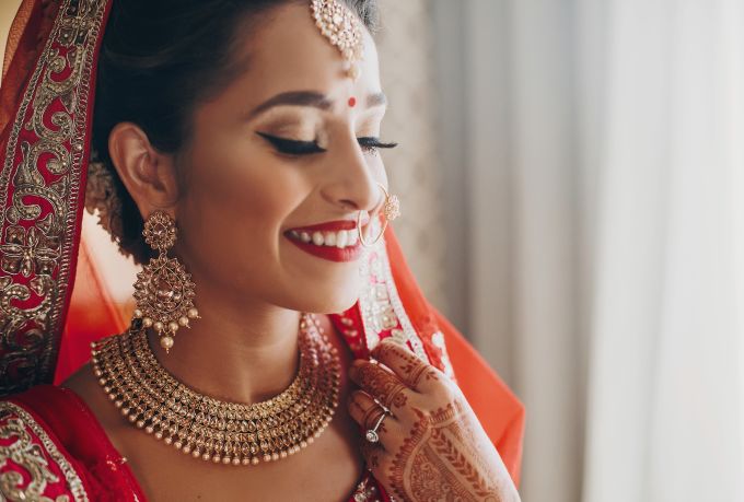 Asian bride in red with henna tattoos on hands