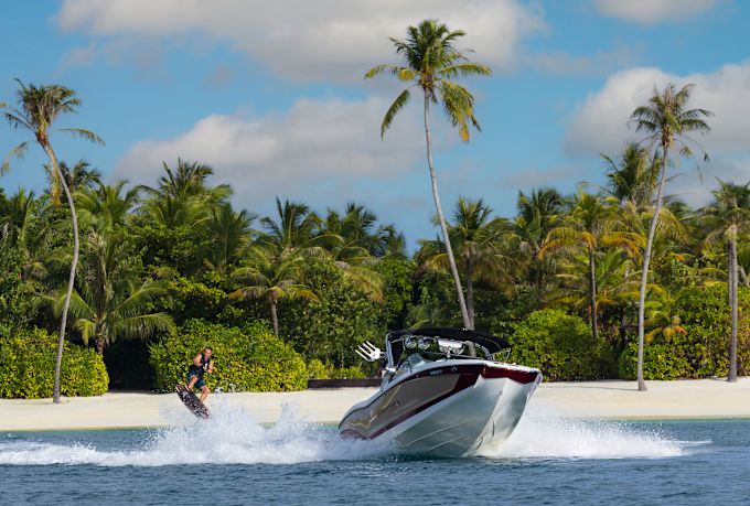 People Water Skiing and View of a Beach with Palm Trees