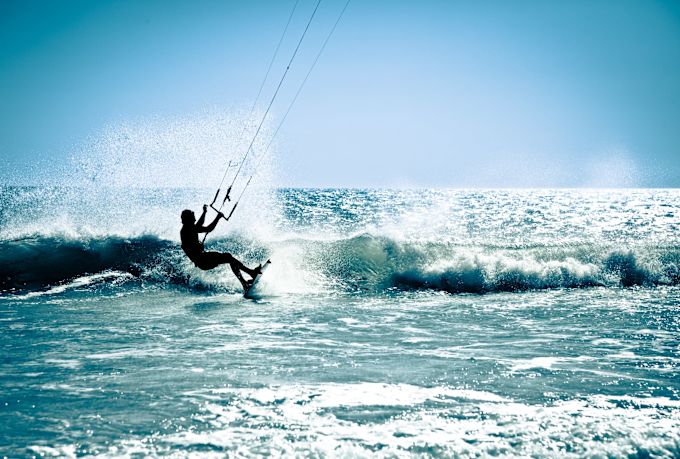 Person windsurfing small waves in the ocean