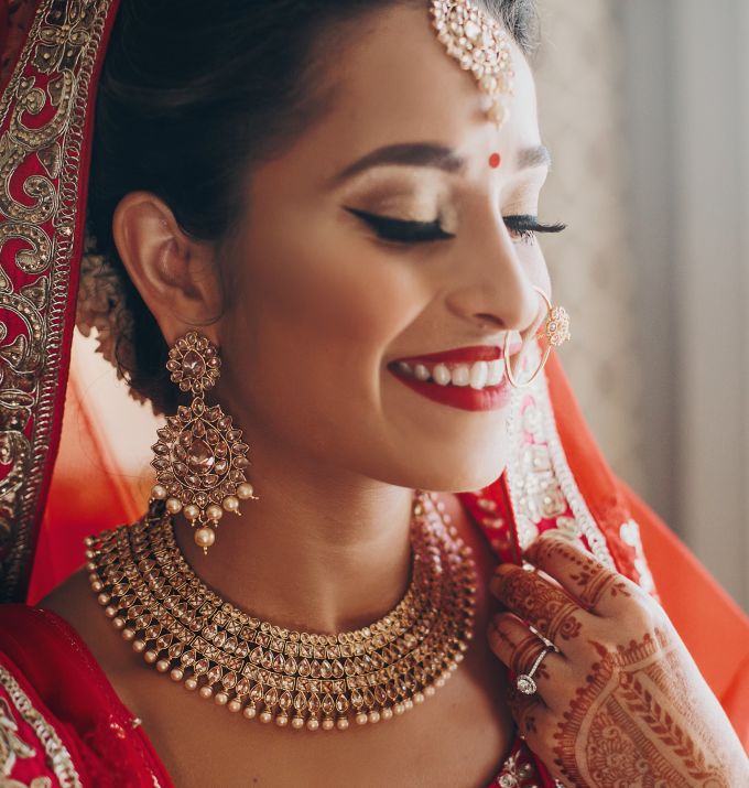Asian bride in red with henna tattoos on hands