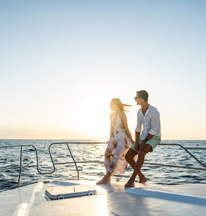 Couple Riding a Boat on the Water at Sunset
