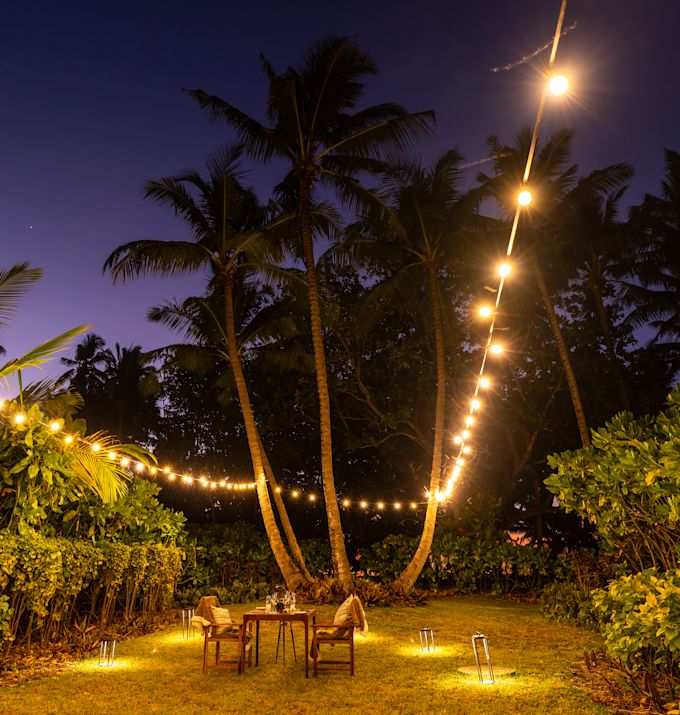 تناول الطعام داخل الفيلا مع طاولة، ومقاعد، وأضواء خيالية، وأشجار استوائية