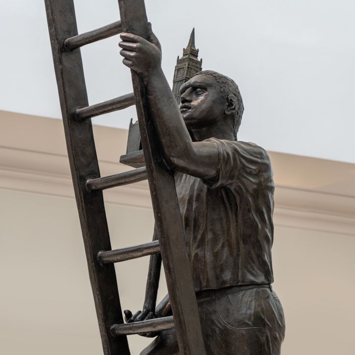 Estatua de un hombre subiendo una escalera