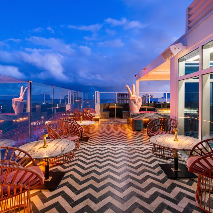 Exterior of Nube at dusk with tables overlooking the ocean