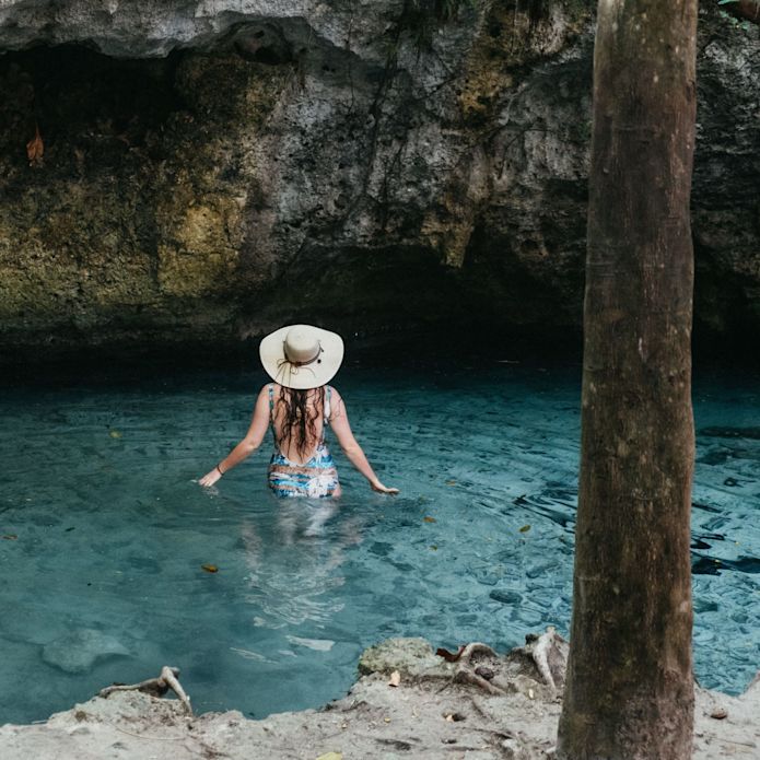 Frauen, die im Cenote ins Wasser waten