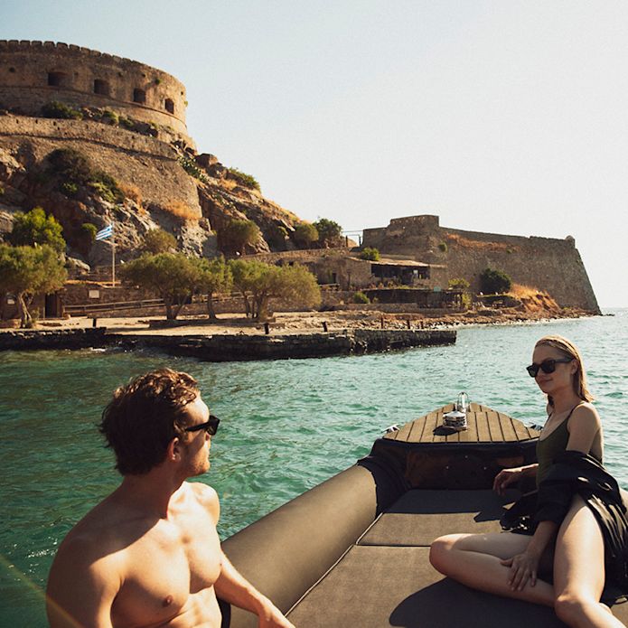 Couple relaxing on a boat near a historic fortress.