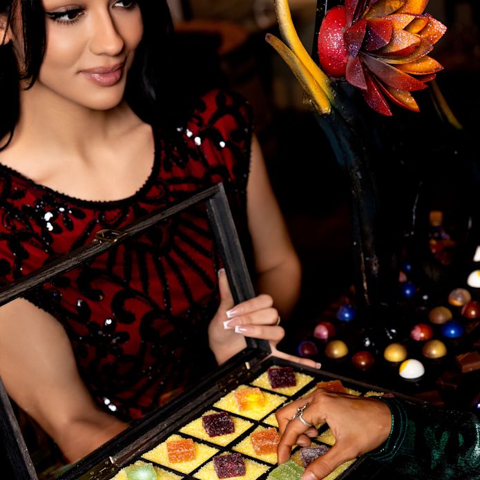 hostess with a sample box of square candies