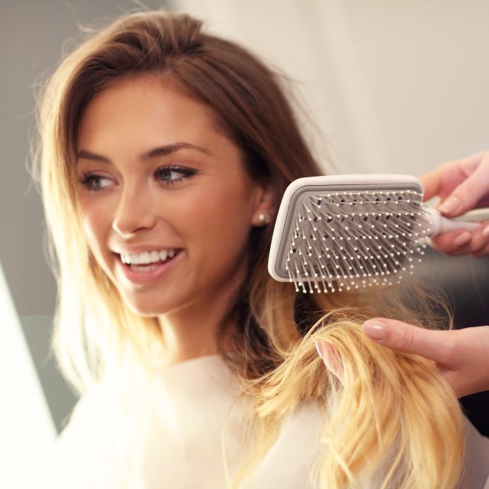 Woman having her hair brushed in salon