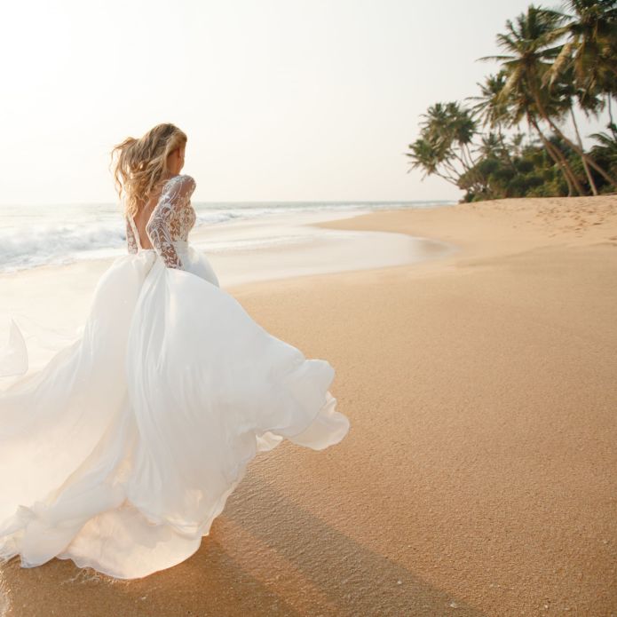 Bride with flowing dress on beach