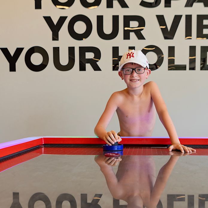 Boy Playing Air Hockey at the Younster Club