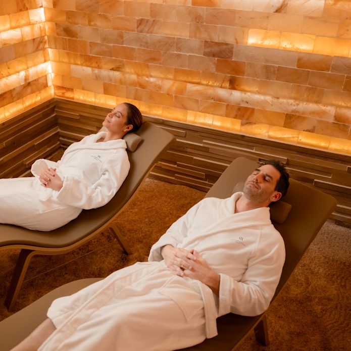 Un homme et une femme se détendant sur une chaise longue dans des peignoirs