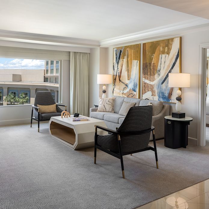 Salle de séjour et vue partielle de la chambre séparée d'une suite d'hôtel