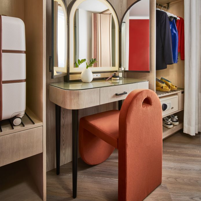 Vanity area in guest room with chair and desk