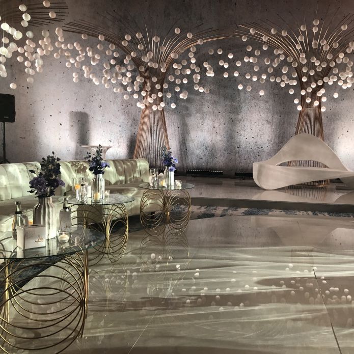 Sitzbereich der Veranstaltungsfläche mit Blumendekoration aus weißen Bällen