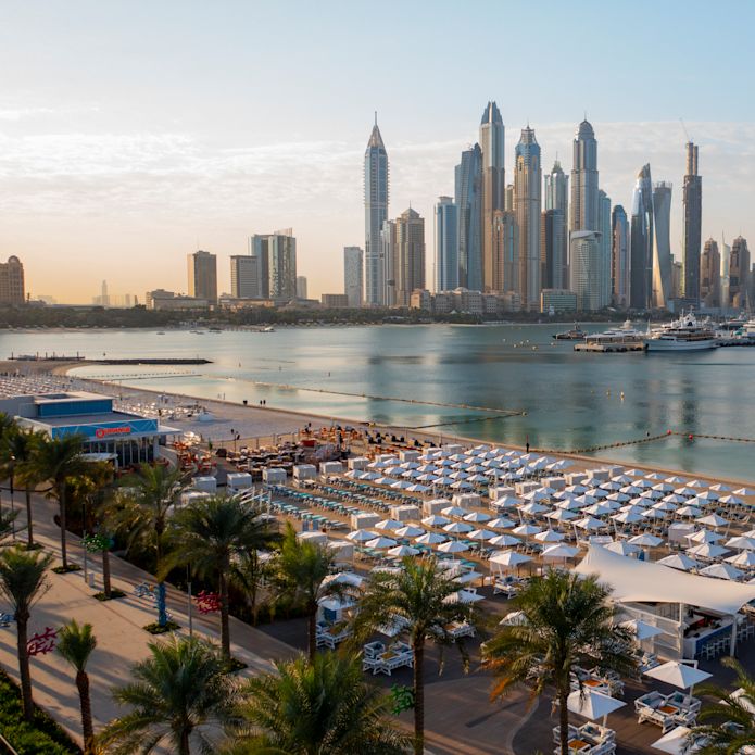 Privéstrand van Hilton Dubai Palm Jumeirah met uitzicht op de grote stad op de achtergrond