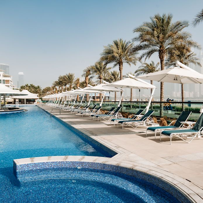 Buitenzwembadgedeelte met palmbomen