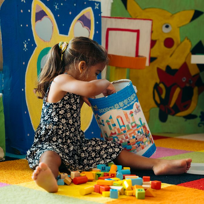 ビルディングブロックで遊ぶキッズクラブの少女