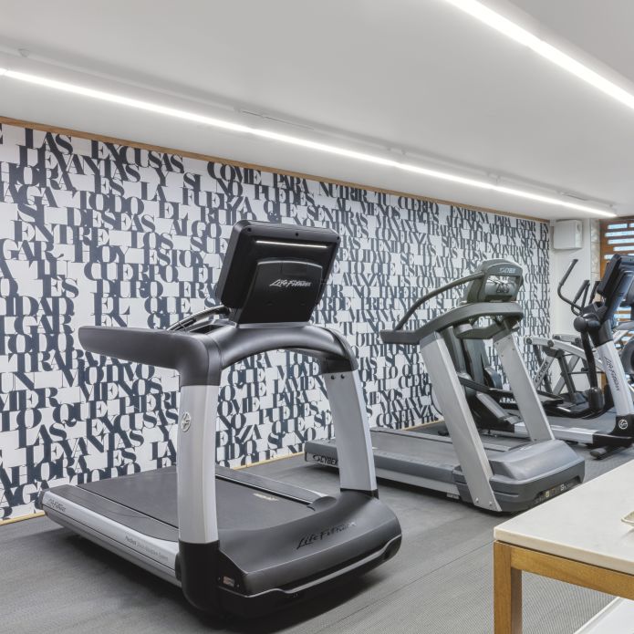 Fitness center treadmill machines with towels on nearby table