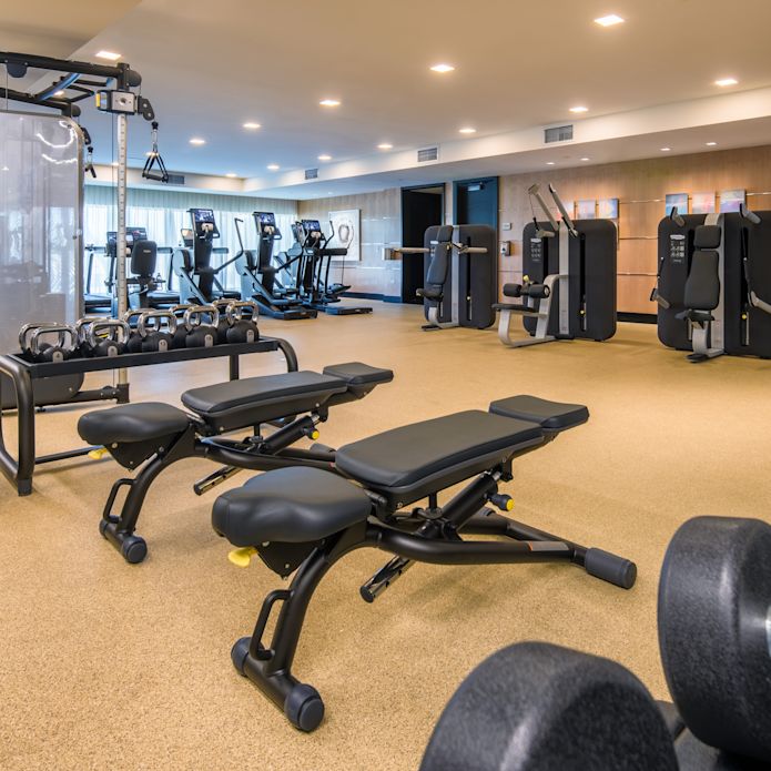Pusat kebugaran dengan bangku dan beban bebas
