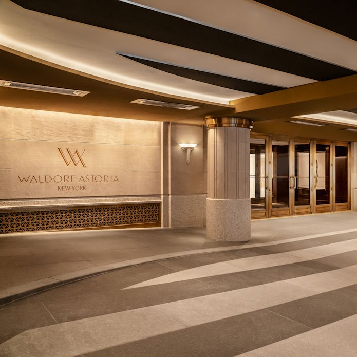 Hotel entrance, with Waldorf Astoria signage and plant