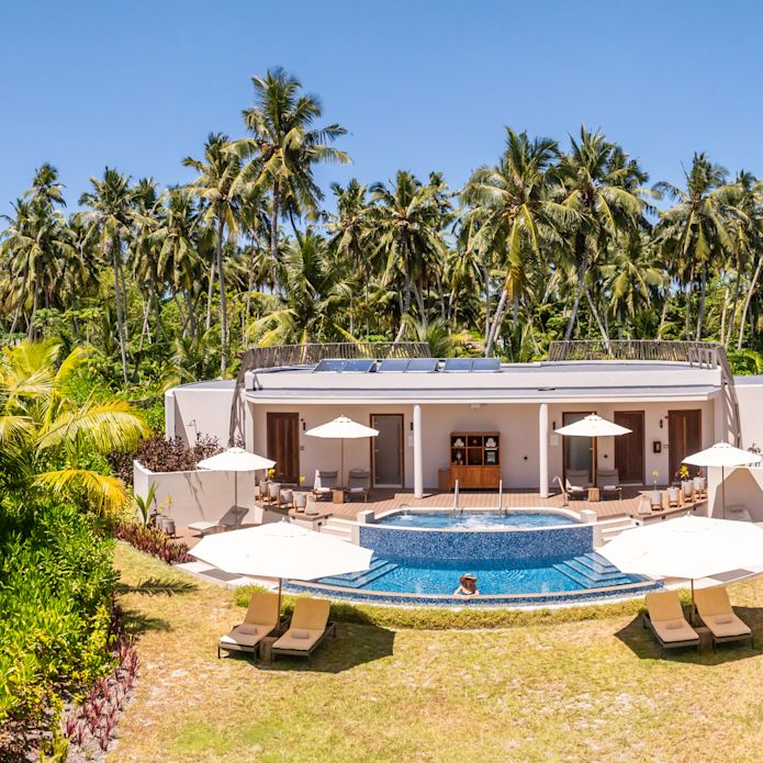 Frau im Außenpool des Spa umgeben von Palmen