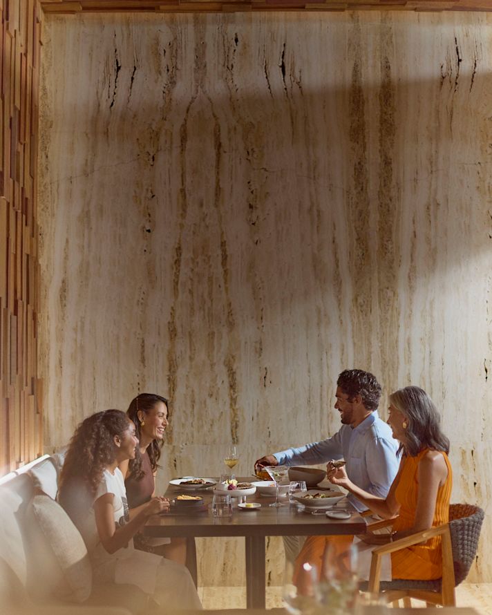 Mother, father, daughter and grandmother enjoying dinner together