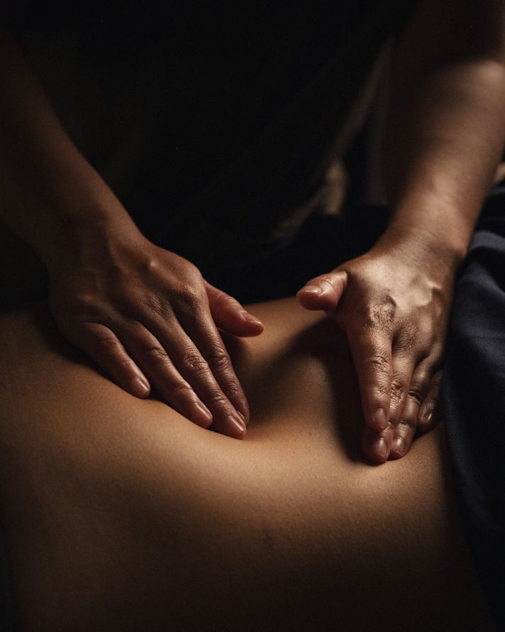 Imagem em close das mãos fazendo massagem relaxante em um ambiente de spa