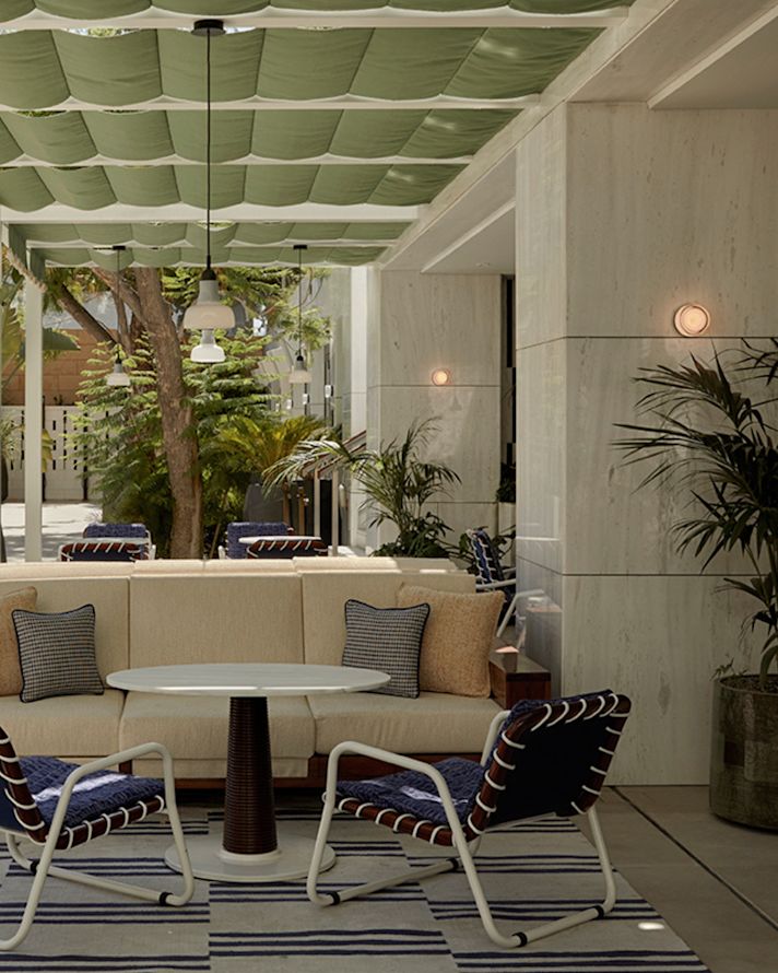 Überdachte Terrasse mit Essbereich im Restaurant "Oasis Pool" mit großen Pflanzen