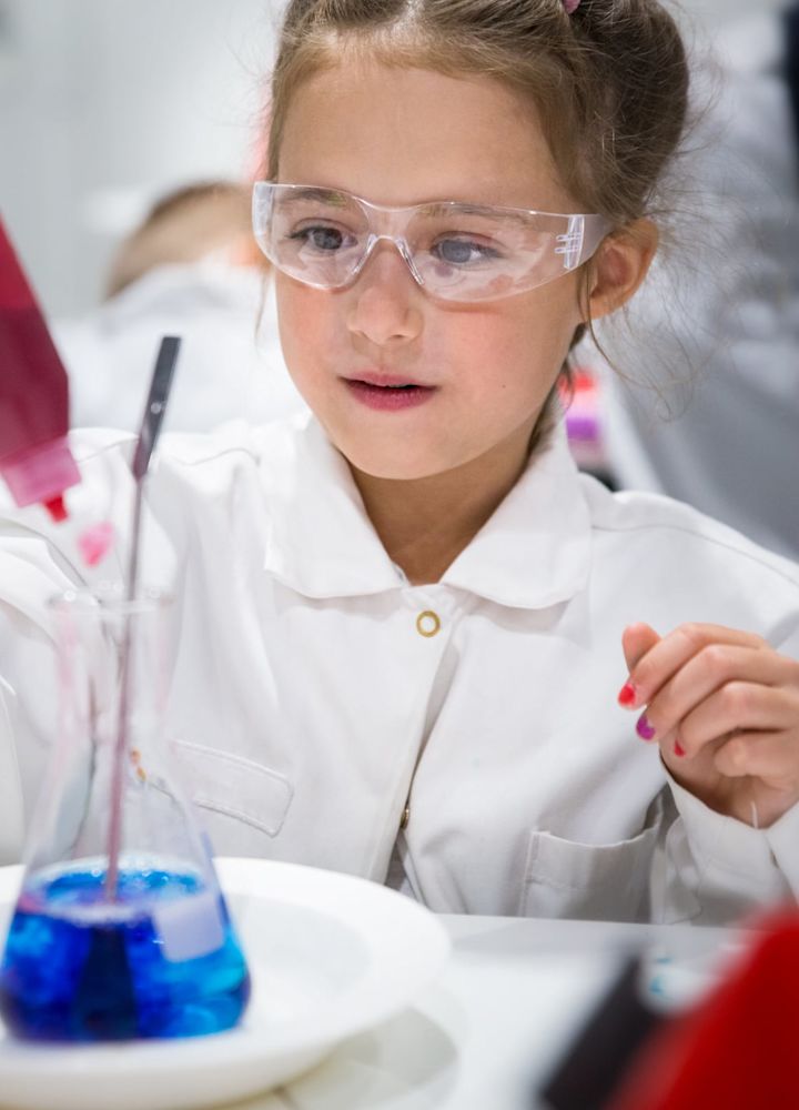Children's chemical laboratory in the scientific-interactive museum. A little girl is passionate about chemical experiments
