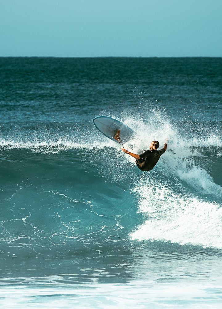 海のサーフボードで波に乗る男性