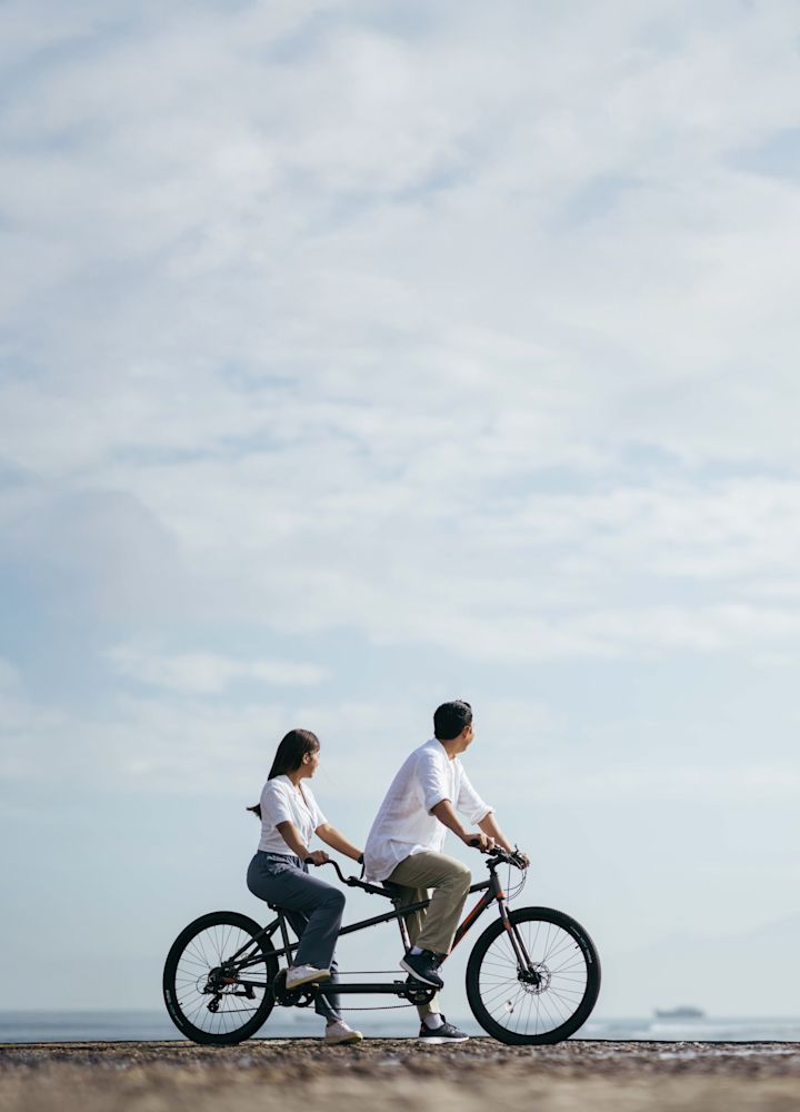 Couple riding bikes at the beach