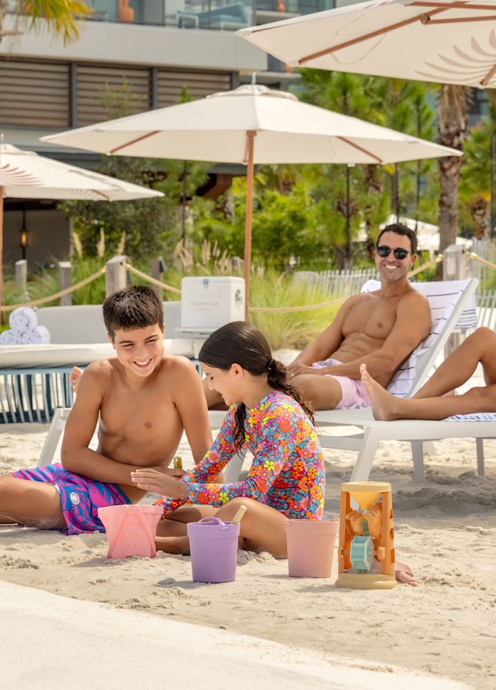 ospiti che si distendono sulla spiaggia, bambini che giocano sulla sabbia