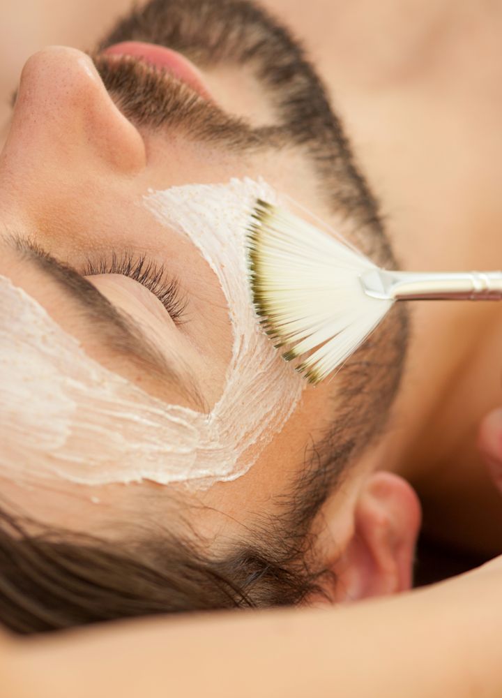 Tampak dari dekat seorang pria sedang mendapatkan masker wajah yang disikat di wajahnya