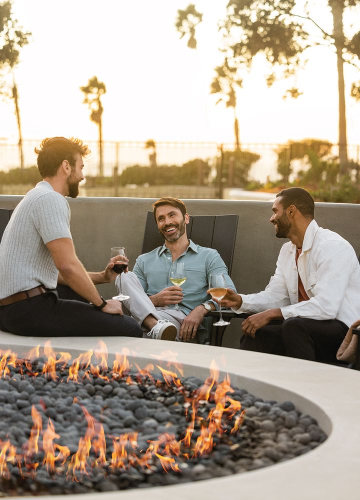 Men Enjoying Drinks in a Patio with a Fire Pit