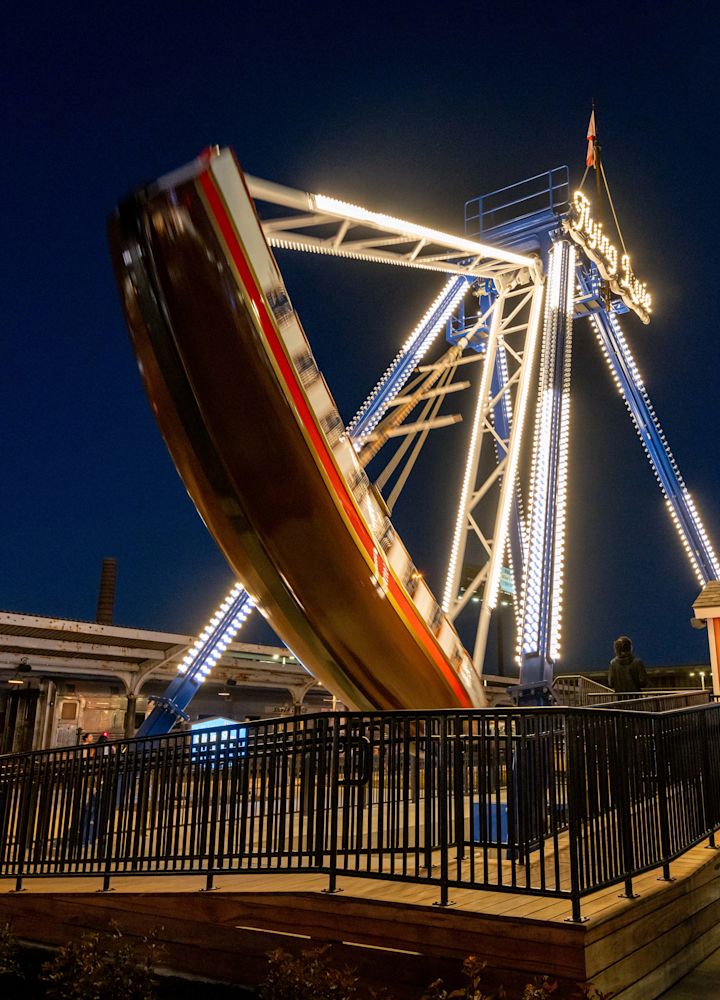 A Person Standing next to a Ride Decorated with Lights