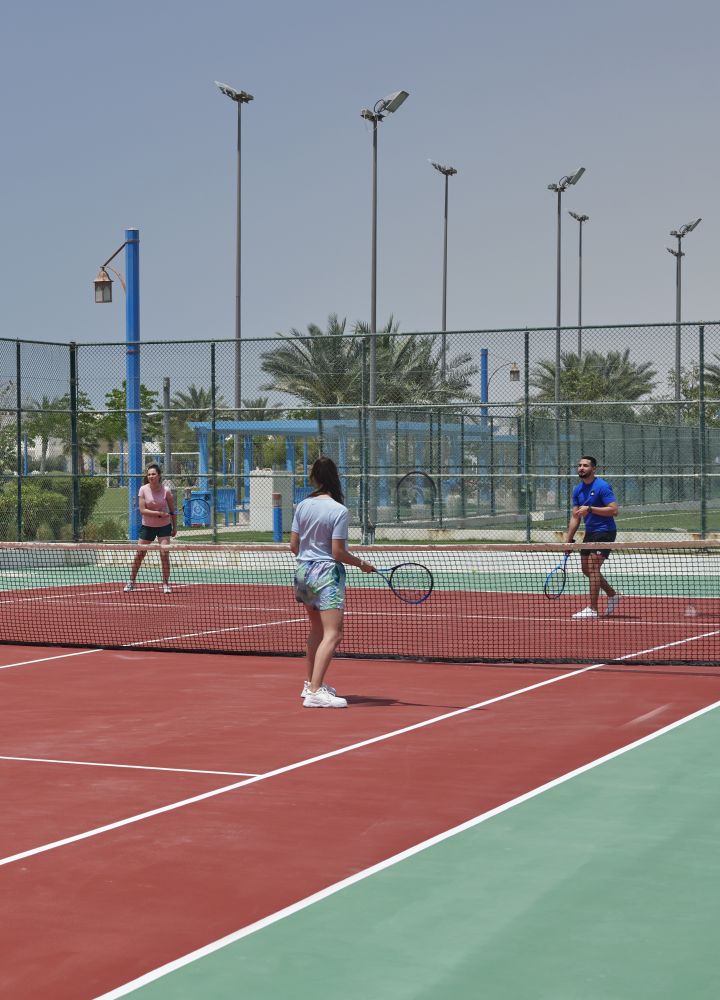 Cancha de tenis con 4 persona jugando