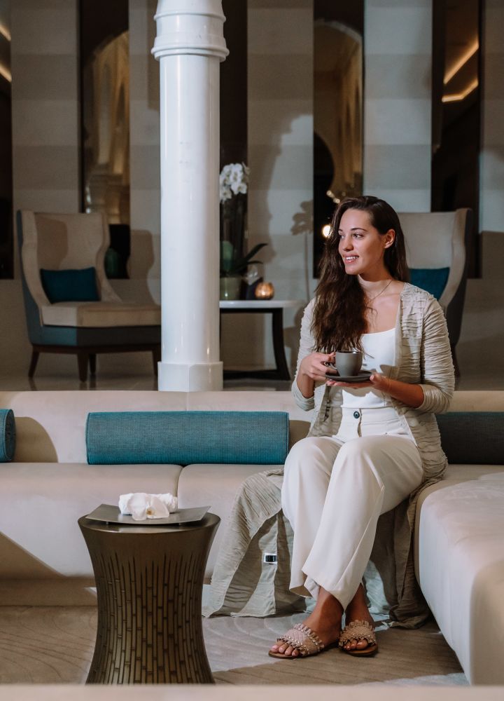 Femme assise sur une chaise confortable buvant du thé