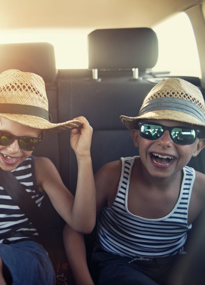 Kids with Sunglasses Laughing in the Back of a Car