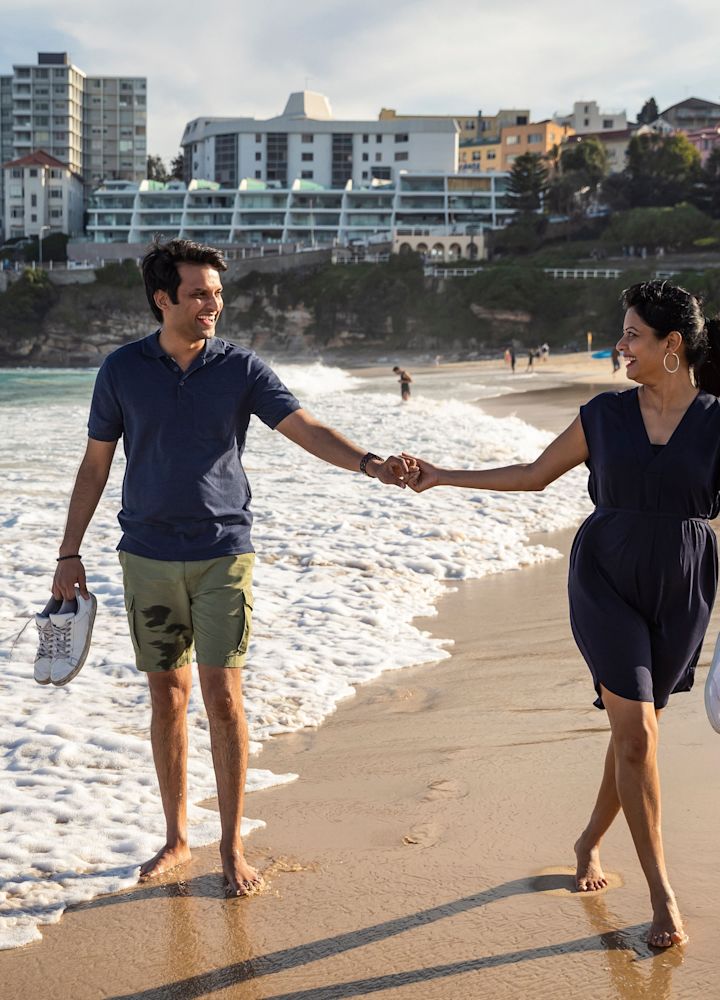 a couple walking hand in hand on the beach