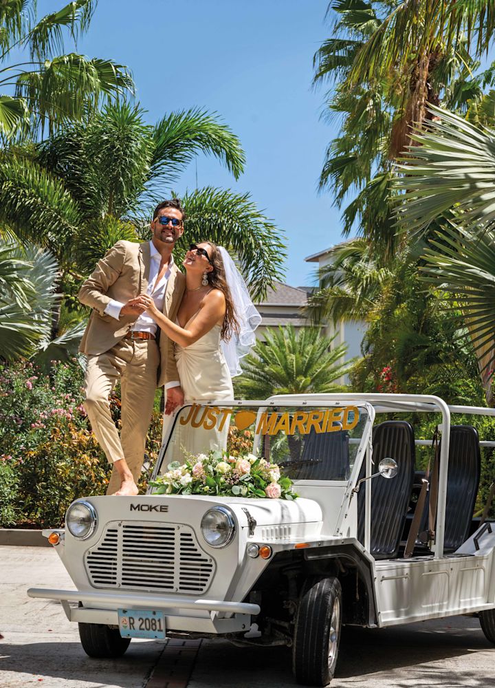 Pareja de pie sobre un recién casado jeep