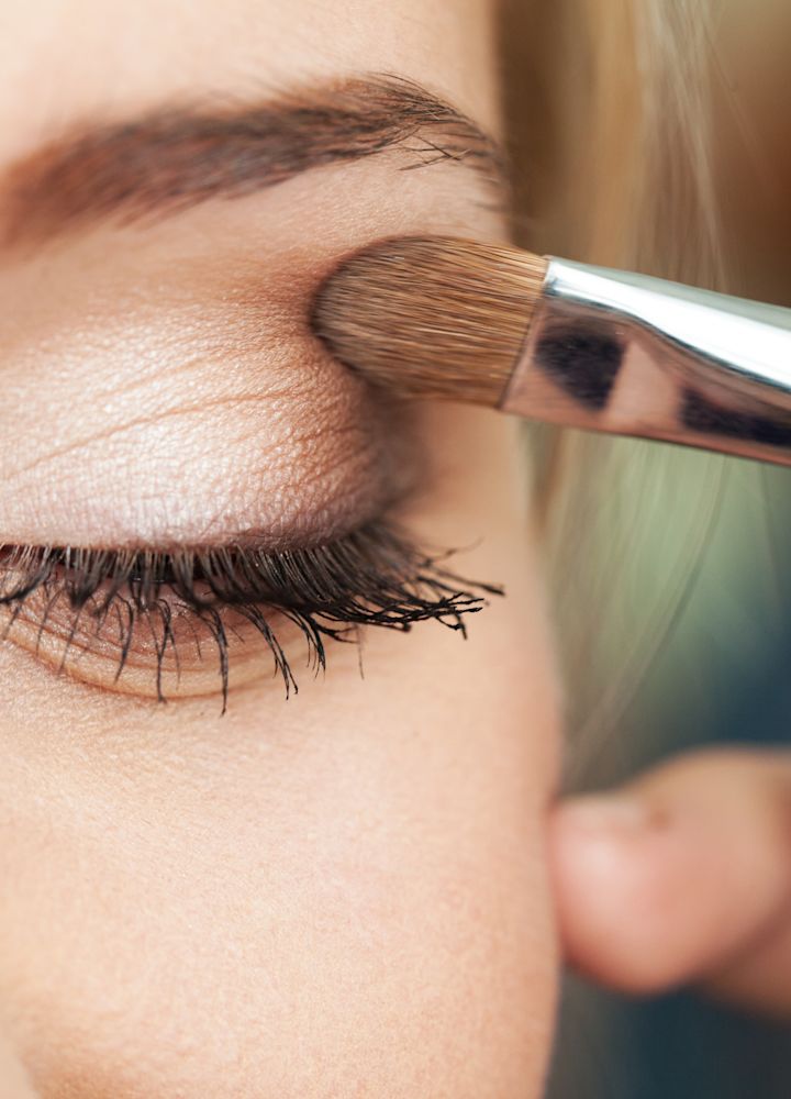 Woman having makeup applied to her eyelid