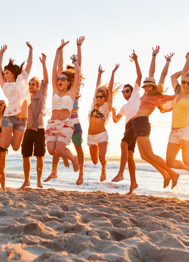 Un groupe d'amis qui saute sur la plage au coucher du soleil