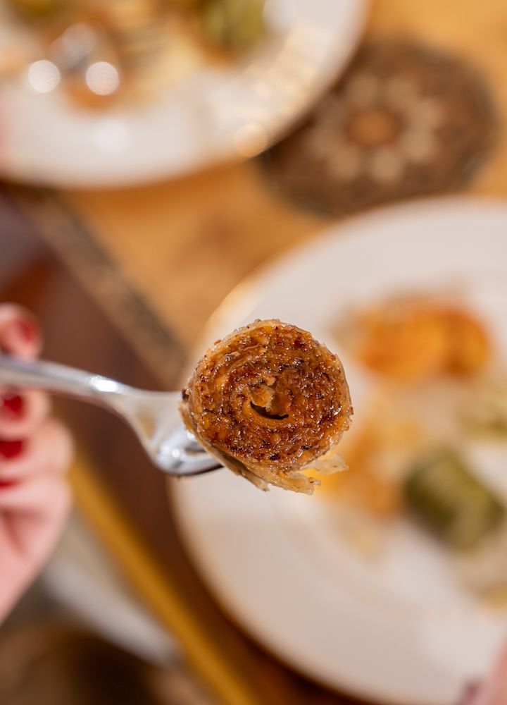 Woman Holding a Fork with Food at a Restaurant