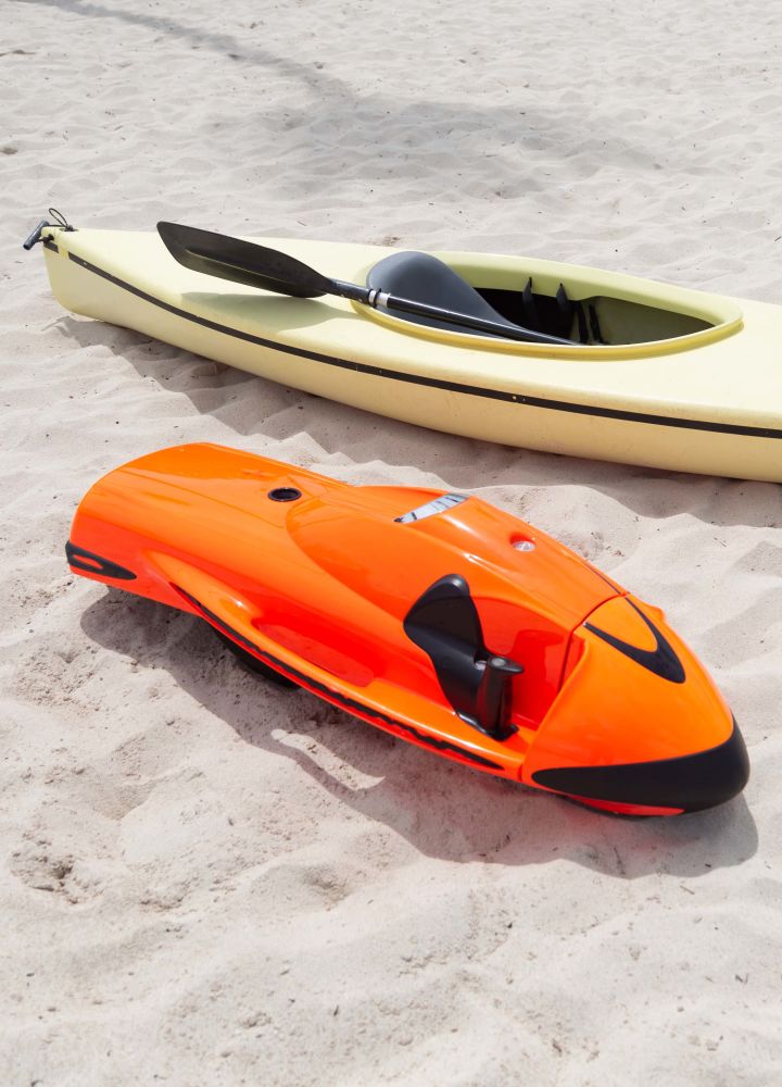 Seabob sitting next to a kayak on the sand