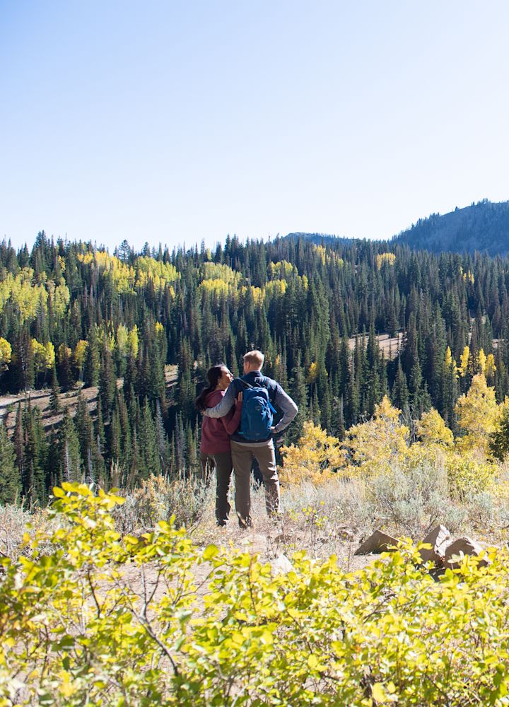 Coppia in piedi su un sentiero pedonale ammirando la vista degli alberi su una montagna