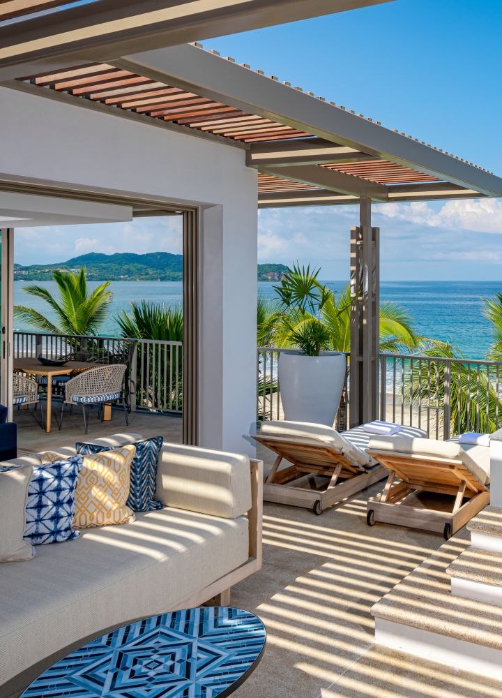 Terraza de la Grand Suite con sala de estar junto a la piscina con vista al mar