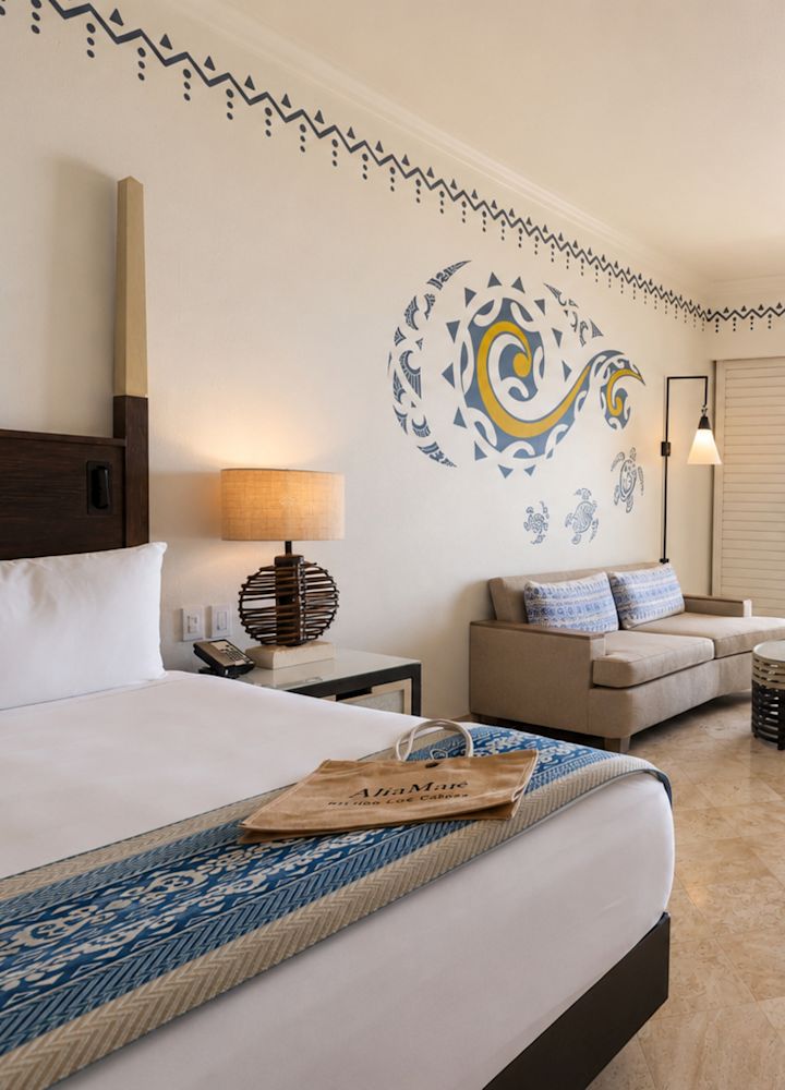 Large bed and living area in a suite with ocean view from balcony