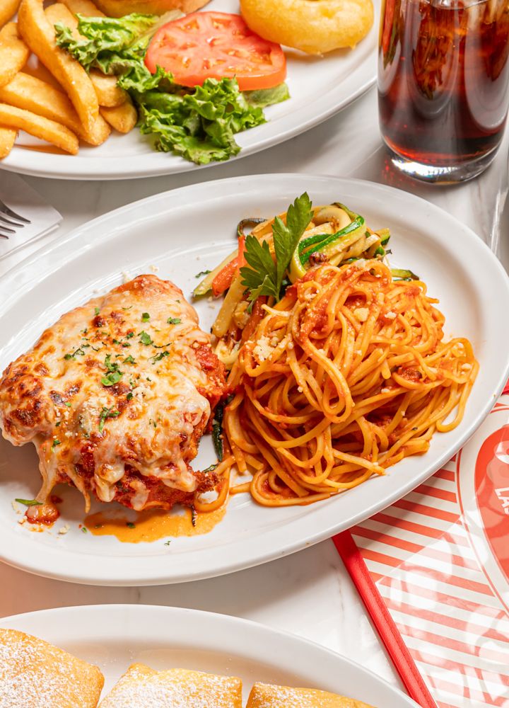 assiettes de pâtes, frites, saucisses, boisson à l'orange